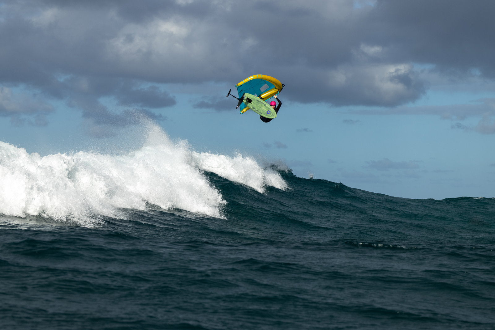 Rider carving a wave on the Duotone Trace SLS 2027 with a Unit D/LAB wing